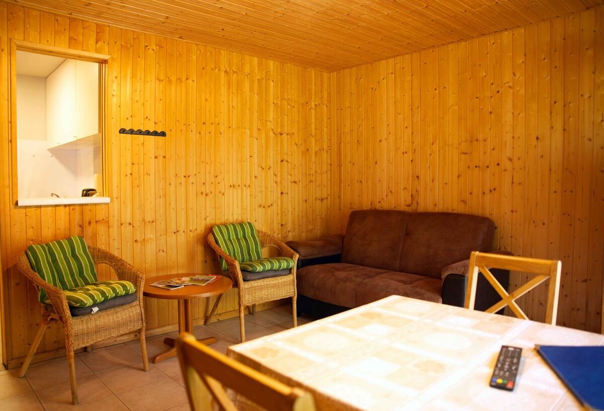 Gemütliches Wohnzimmer mit Holzverkleidung im Bungalow